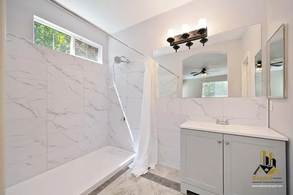 a bathroom with a sink a toilet and shower