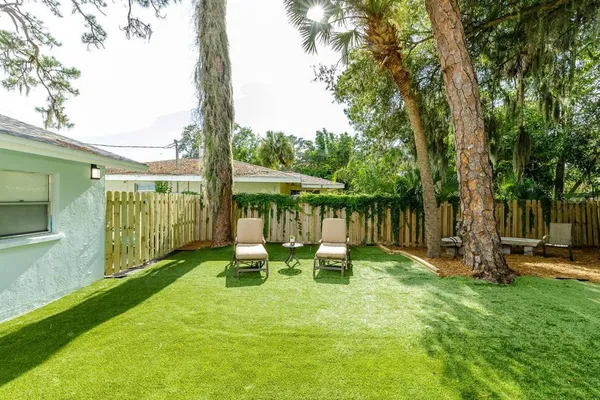 a view of a backyard with table and chairs under an umbrella
