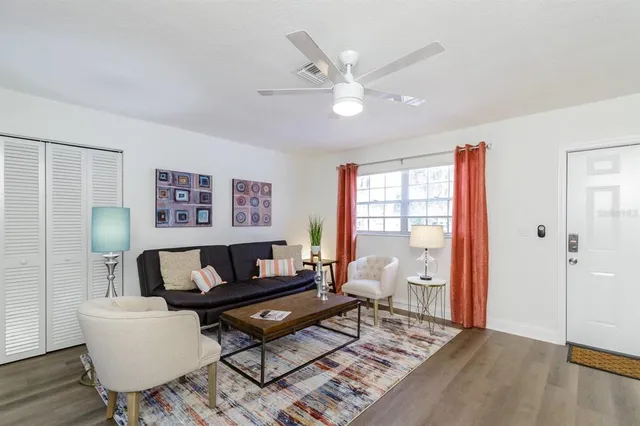 a living room with furniture a rug and a window