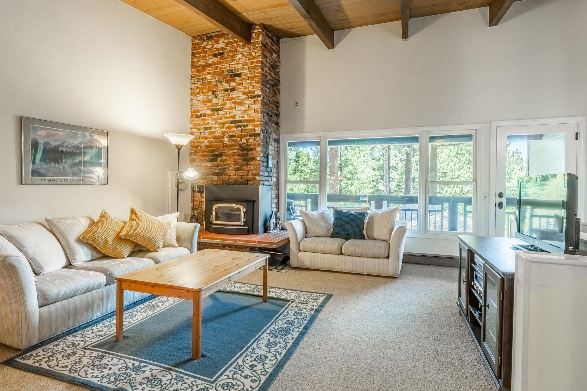 50 Hidden Valley Road, Unit 17 Mammoth Lakes, CA 93546 - Photo 3 of 40 Living room featuring a prominent brick fireplace with a wood-burning insert