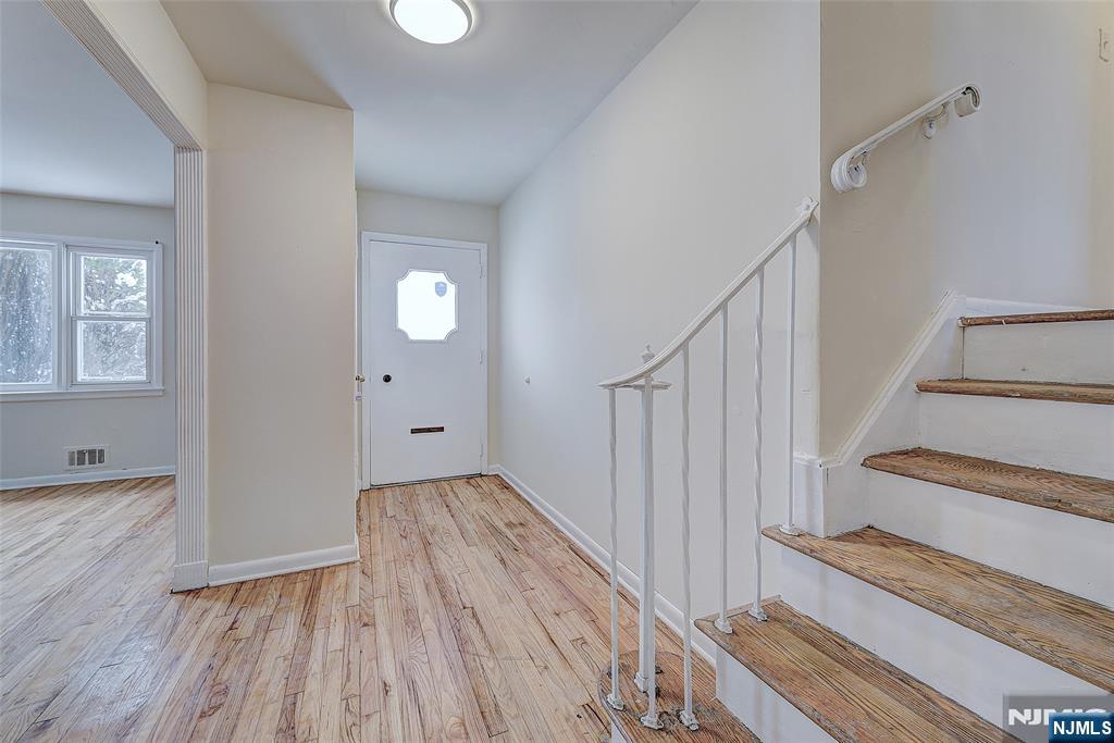 27 Old Short Hills Road West Orange, NJ 07052 - Photo 3 of 35 a view of a hallway with wooden floor and staircase