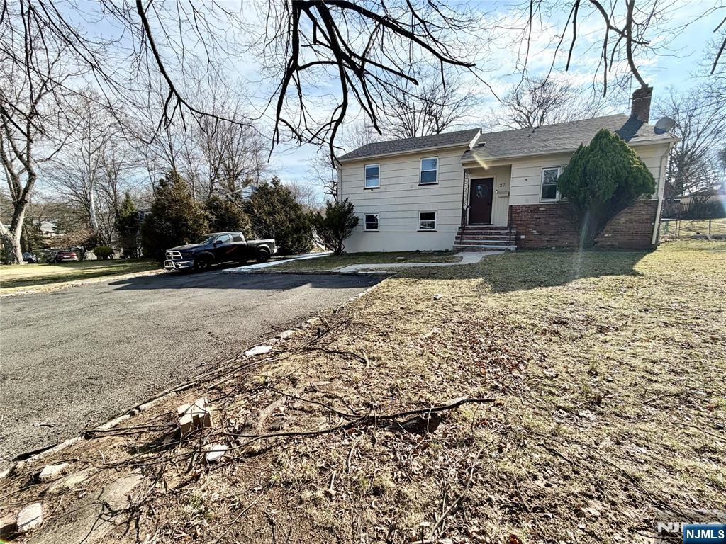 27 Old Short Hills Road West Orange, NJ 07052 - Photo 32 of 35 a view of a white house with a yard covered in snow