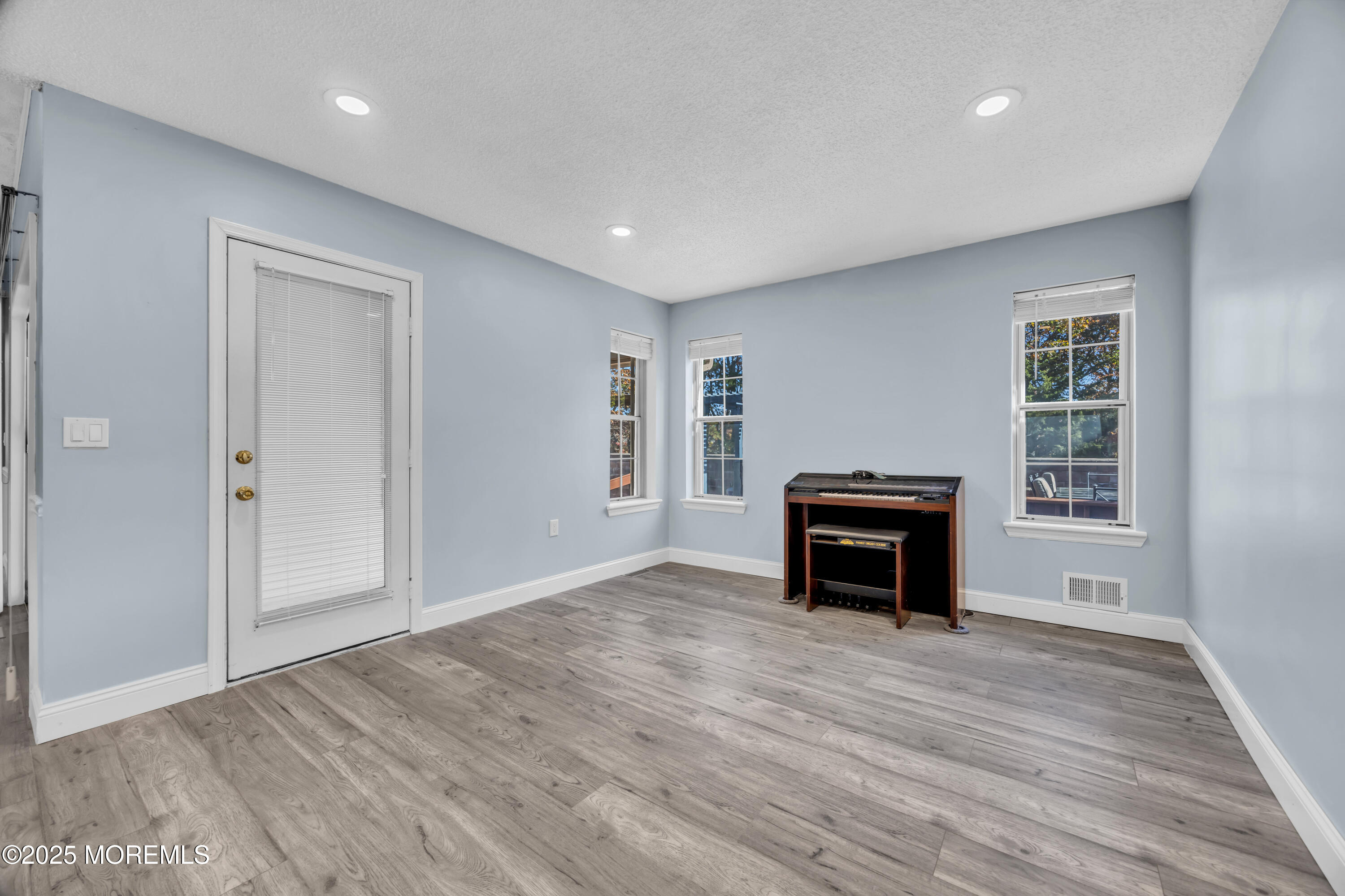 12 Thatcher Court Jackson, NJ 08527 - Photo 13 of 50 an empty room with windows a fireplace and wooden floor