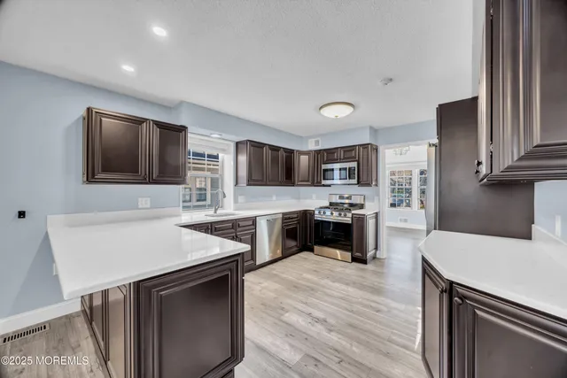 a kitchen with stainless steel appliances granite countertop a sink stove and refrigerator