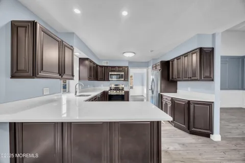 a kitchen with granite countertop a sink stove and refrigerator