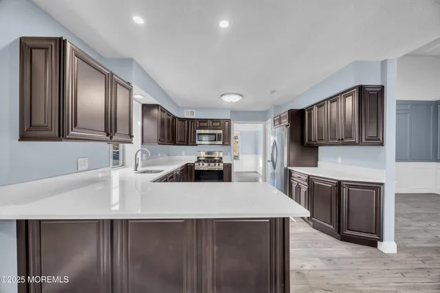 a kitchen with granite countertop a sink stove and refrigerator