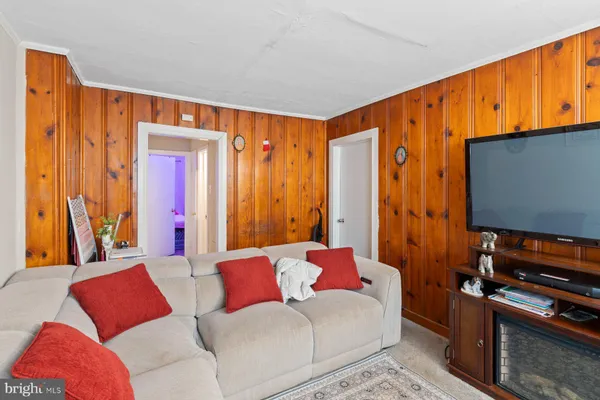 a living room with furniture a flat screen tv and a window