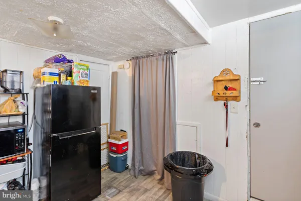 a utility room with refrigerator and washer