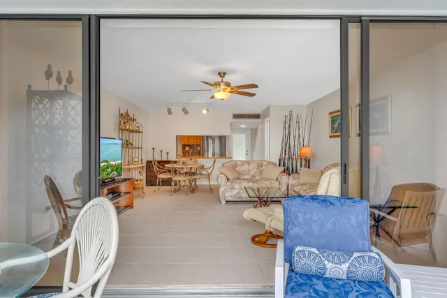 a living room with furniture a flat screen tv and a large window
