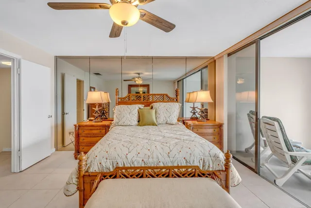 a view of a patio with couches table and chairs potted plants and palm trees
