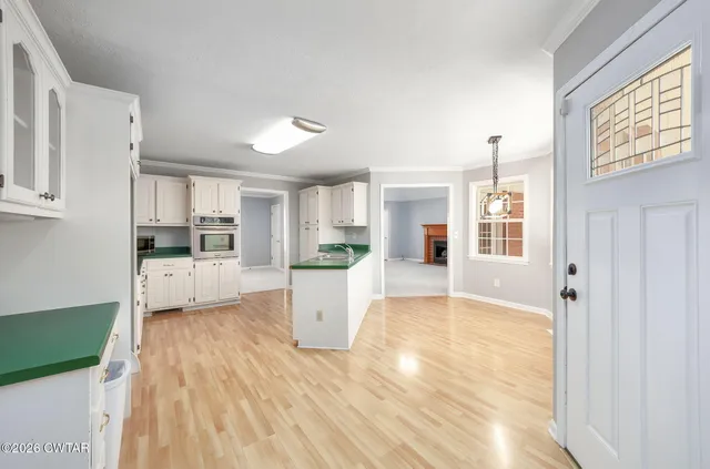 a view of empty room with wooden floor and ceiling fan