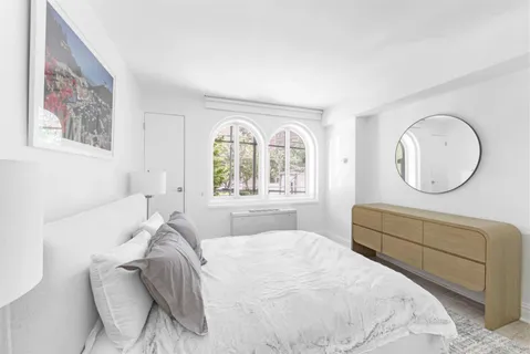 a bedroom with a bed mirror and window