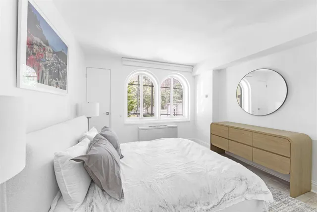 a bedroom with a bed mirror and window