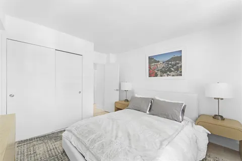 a bedroom with a bed and a lamp on the dresser