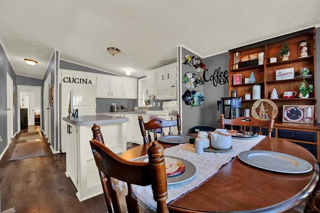 a view of a dining room with furniture a rug and wooden floor
