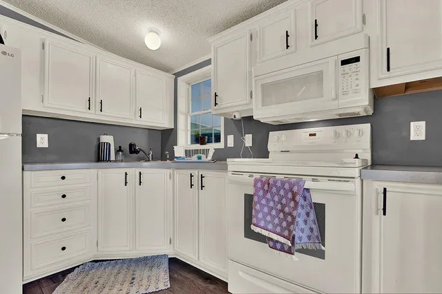 a kitchen with stainless steel appliances granite countertop white cabinets sink and dishwasher