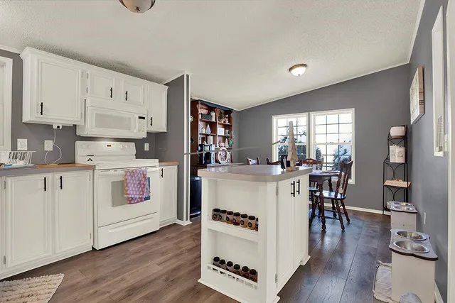 a kitchen with a stove top oven and white cabinets