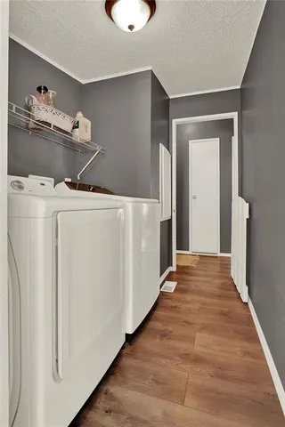 a view of a kitchen with refrigerator and wooden floor