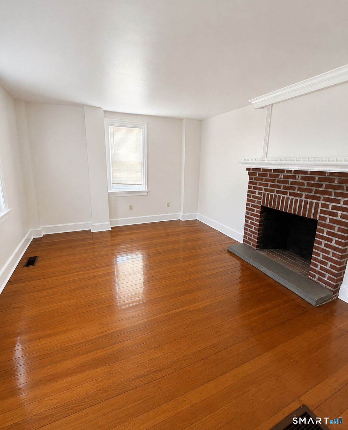 493 High Street Milford, CT 06461 - Photo 3 of 10 a view of empty room with wooden floor and fireplace