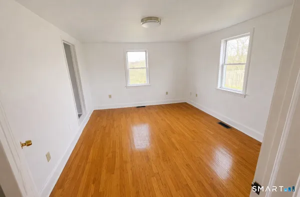 a view of a room with wooden floor and window