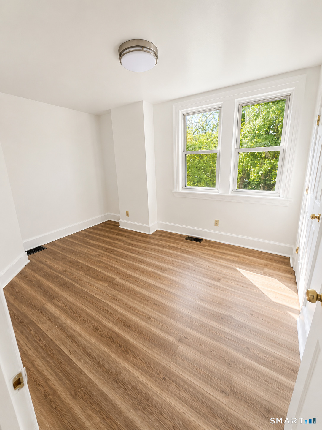 493 High Street Milford, CT 06461 - Photo 7 of 10 a view of an empty room with wooden floor and a window