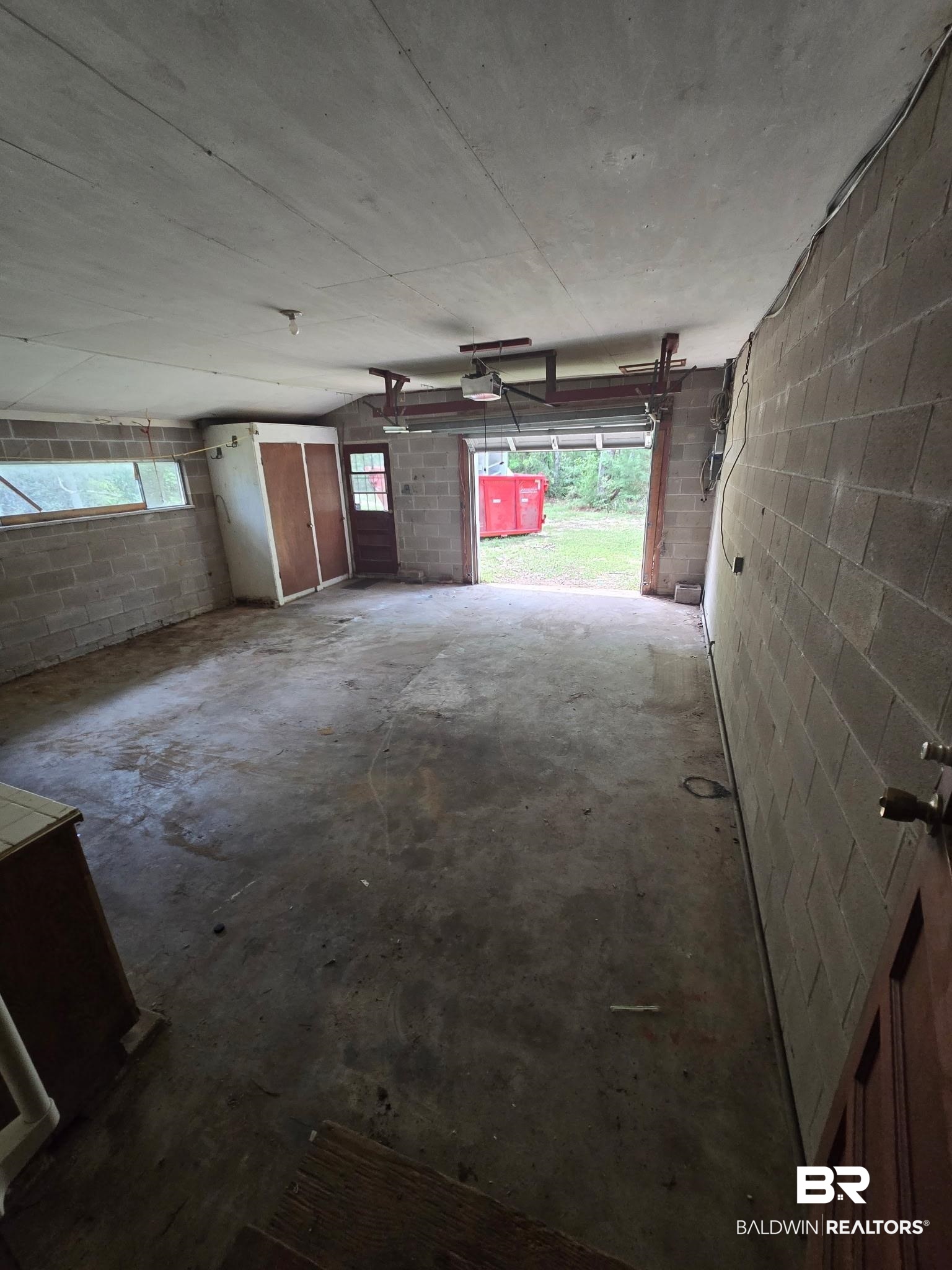 8731 Byrnes Lake Road Bay Minette, AL 36507 - Photo 10 of 14 Garage featuring a garage door opener and concrete block wall