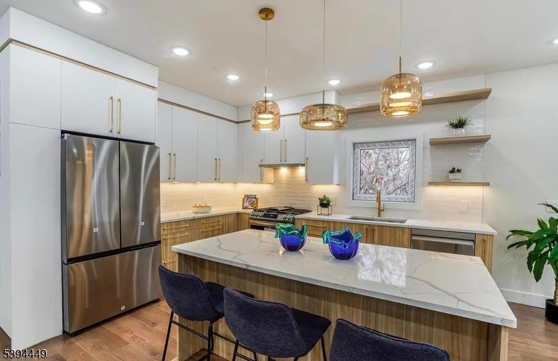376 21st Street Irvington, NJ 07111 - Photo 7 of 24 a kitchen with a dining table chairs and refrigerator