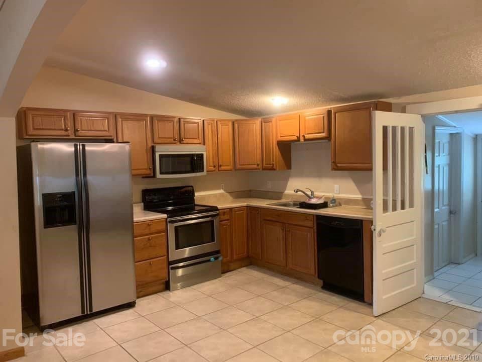 290 John Smith Road Rutherfordton, NC 28139 - Photo 3 of 16 a kitchen with granite countertop a refrigerator and a stove top oven