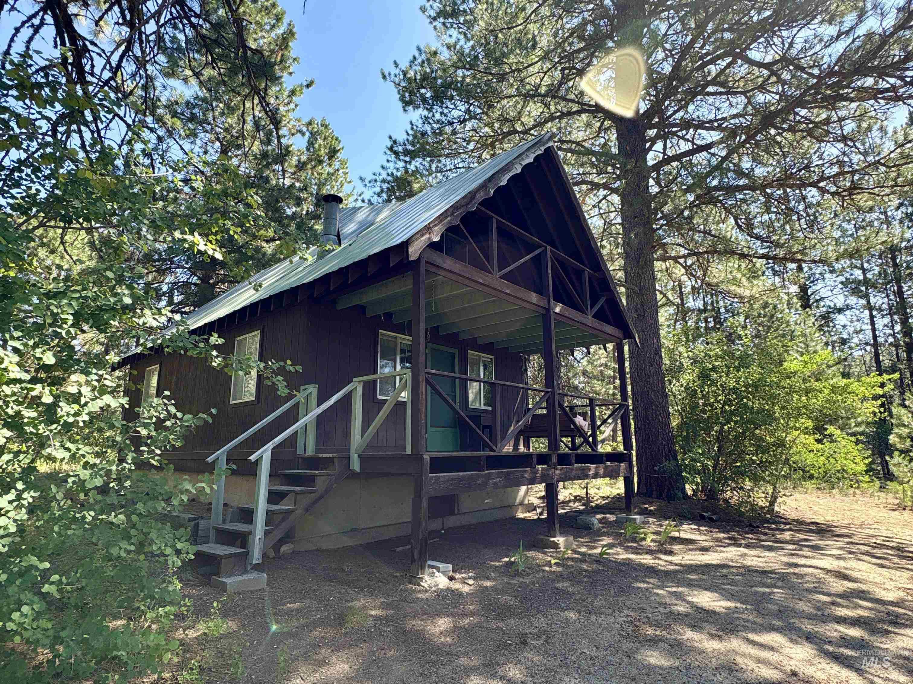 1100 Strawberry Loop Road Mountain Home, ID 83647 - Photo 1 of 20 Wood-sided cabin featuring a metal roof and an elevated covered porch