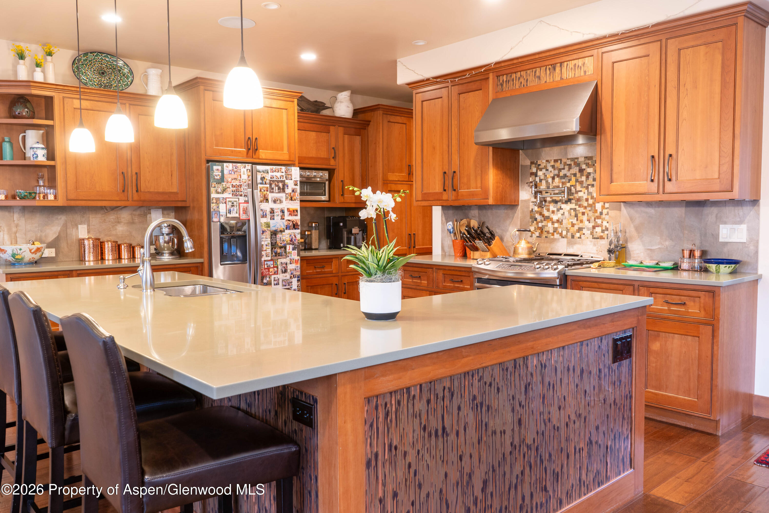 109 Valley Court Basalt, CO 81621 - Photo 5 of 41 a kitchen with stainless steel appliances kitchen island granite countertop a table chairs in it and wooden floors