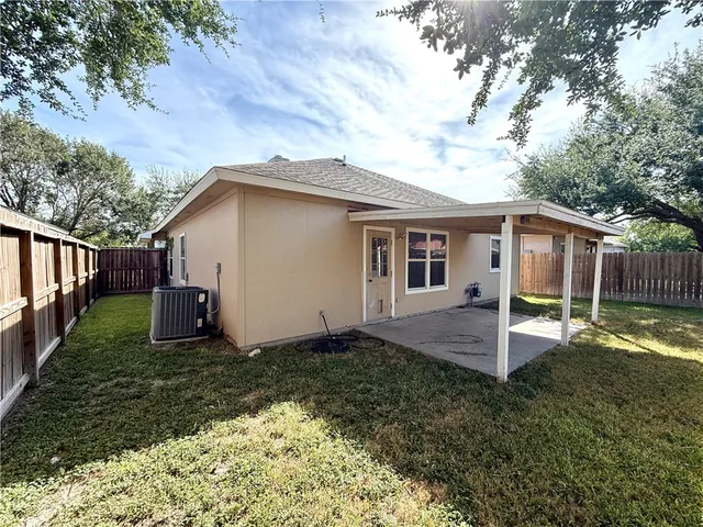 a view of a house with backyard and tree