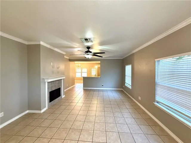 a view of an empty room with window and fire place
