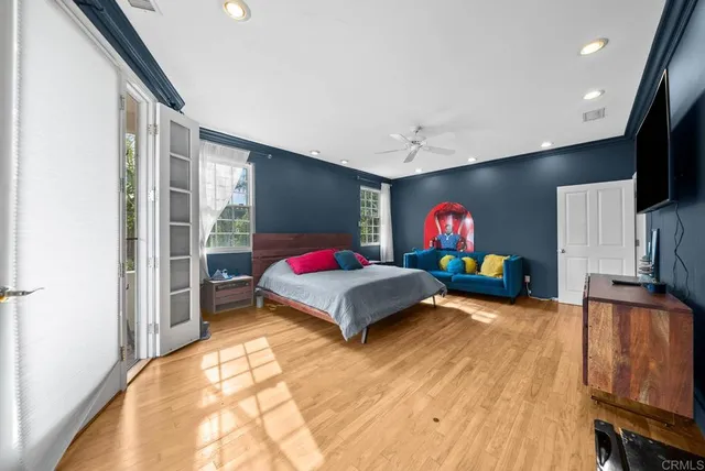 a spacious bedroom with a bed and a flat screen tv