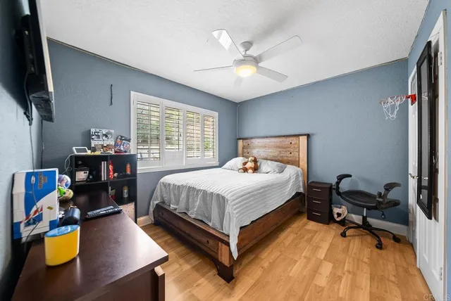 a bedroom with a bed desk and a window