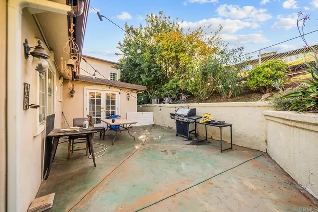 a view of a patio with table and chairs and couches with wooden floor and fence