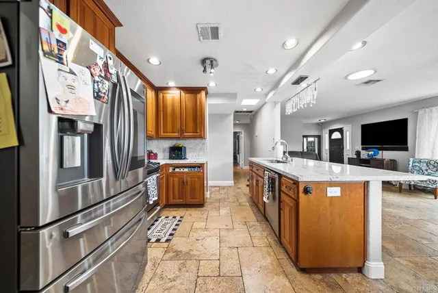 a large kitchen with stainless steel appliances kitchen island granite countertop a large counter top and stainless steel appliances