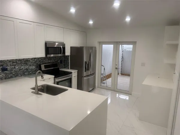 a kitchen with stainless steel appliances a refrigerator sink and microwave