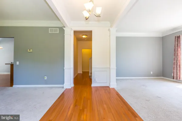 a view of a room with wooden floor and a ceiling fan
