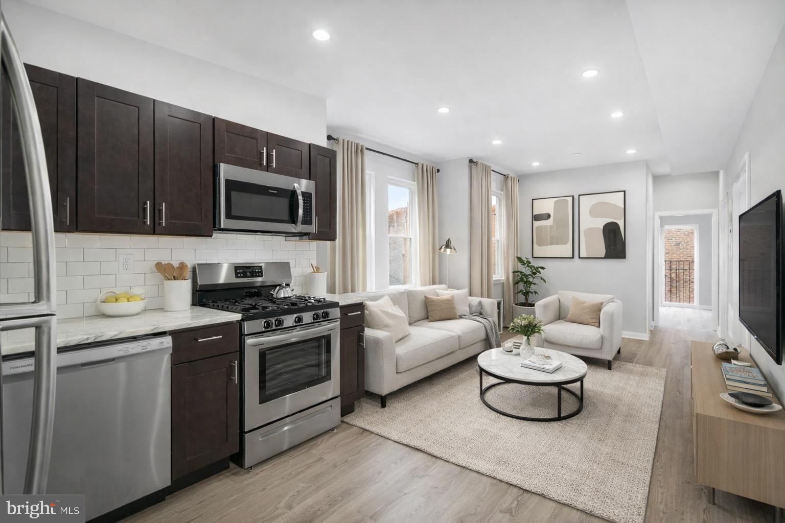a kitchen with furniture a sink a microwave a refrigerator and cabinets