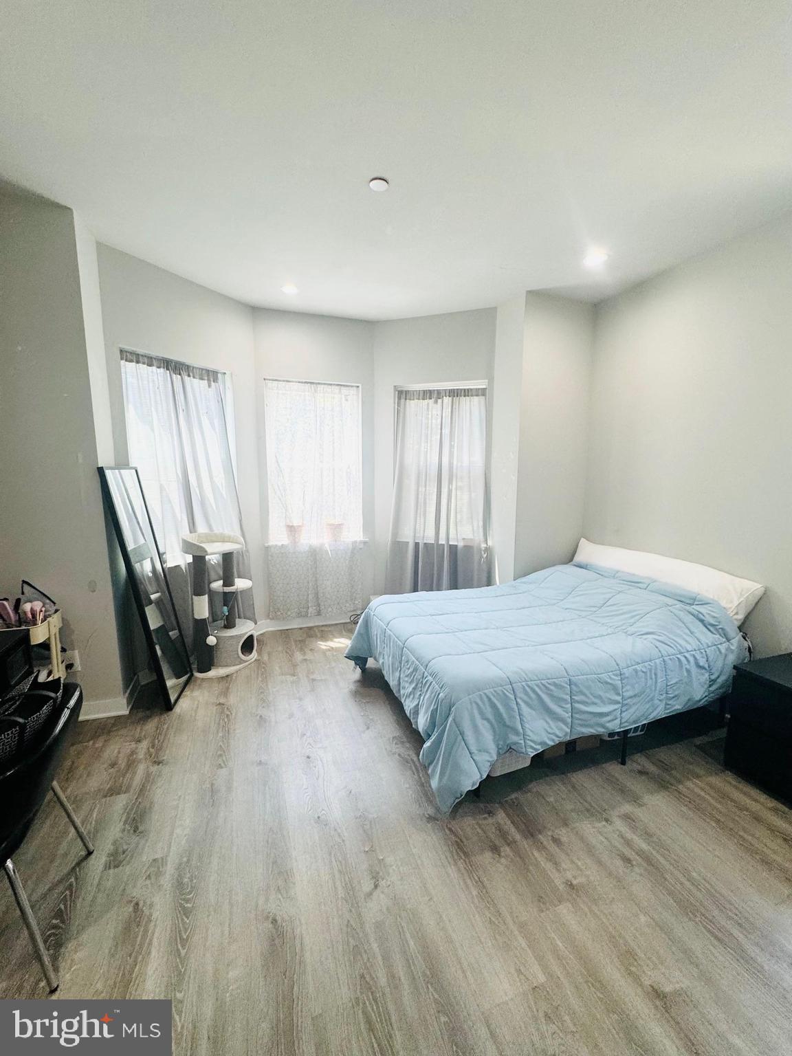 2327 Wharton Street, Unit 2 Philadelphia, PA 19146 - Photo 14 of 19 a bedroom with a bed and wooden floor