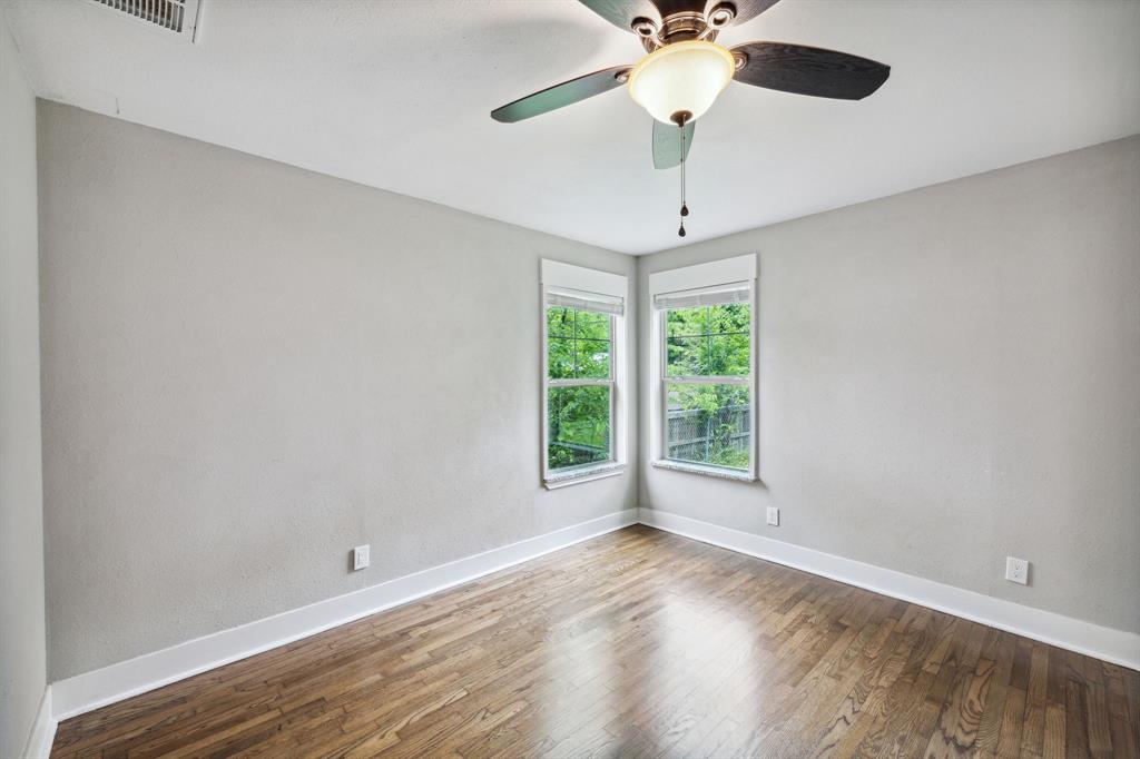 1605 South Walnut Street Sherman, TX 75090 - Photo 16 of 28 an empty room with wooden floor chandelier fan and windows