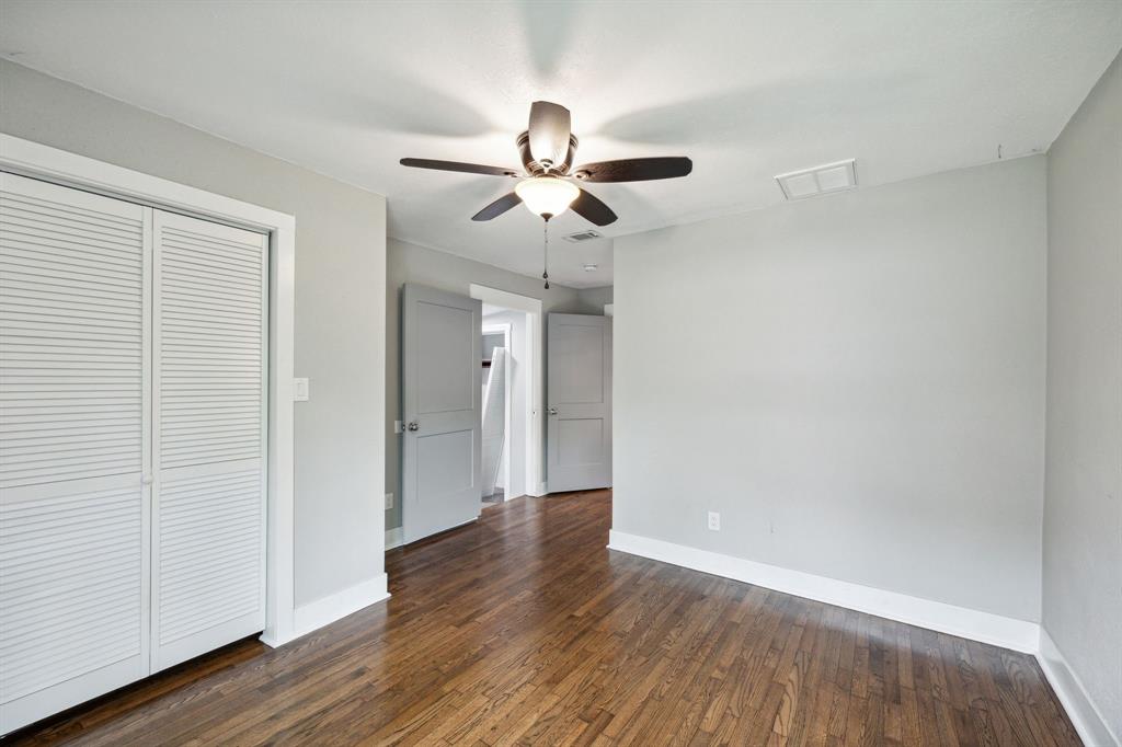 1605 South Walnut Street Sherman, TX 75090 - Photo 17 of 28 an empty room with wooden floor ceiling fan and windows