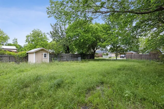 a view of green field with trees in the background