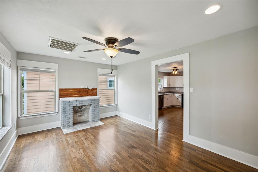 1605 South Walnut Street Sherman, TX 75090 - Photo 3 of 28 a view of a livingroom with a fireplace a ceiling fan and wooden floor