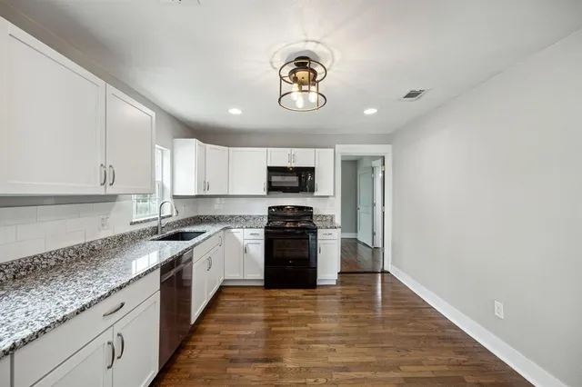 a large kitchen with stainless steel appliances granite countertop a stove and a sink