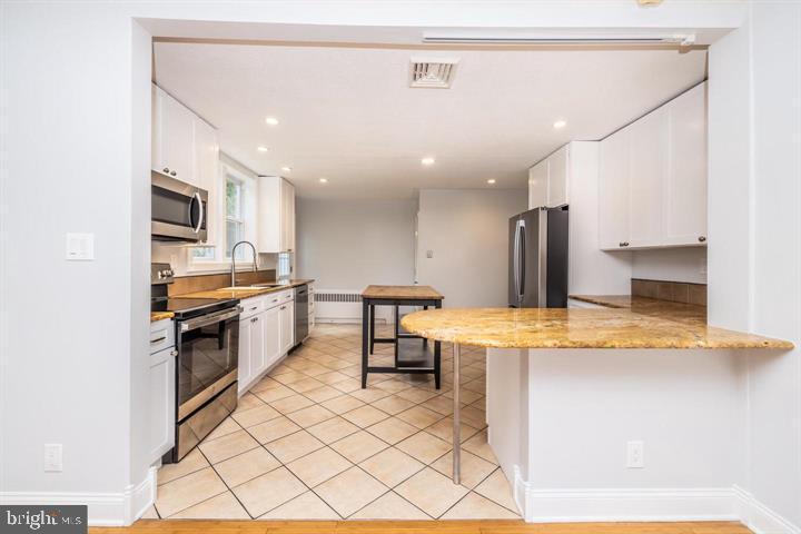 902 Croton Road Wayne, PA 19087 - Photo 12 of 37 a kitchen with stainless steel appliances kitchen island granite countertop a refrigerator and a stove top oven