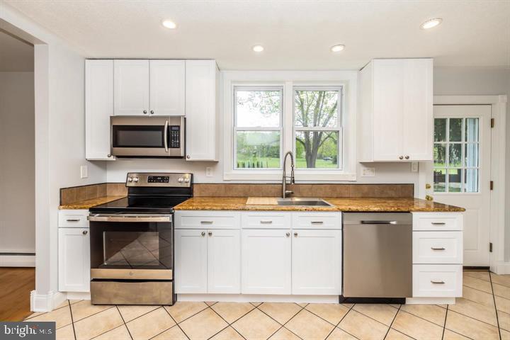 902 Croton Road Wayne, PA 19087 - Photo 14 of 37 a kitchen with granite countertop a stove top oven sink and cabinets