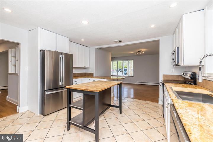 902 Croton Road Wayne, PA 19087 - Photo 16 of 37 a kitchen with granite countertop a refrigerator and a stove top oven