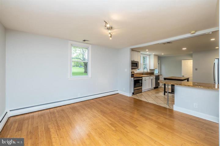 902 Croton Road Wayne, PA 19087 - Photo 10 of 37 a view of an empty room with kitchen view and a window