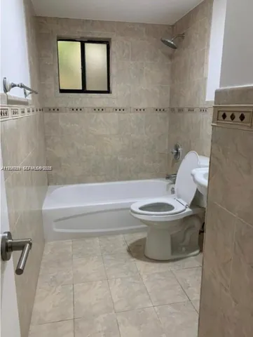 a white toilet sitting next to a bath tub